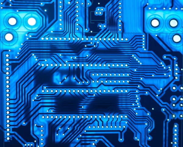 Blue technological background. Background on theme of modern equipment. Digital circuit board is blue. Computer circuit board close-up. Background consists of a circuit board. Technology texture.