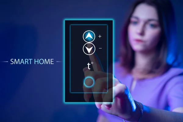 Internet of smart things. Smart home system control. Girl controls temperature in smart home. She controls temperature by clicking on virtual screen. management of home using a virtual panel