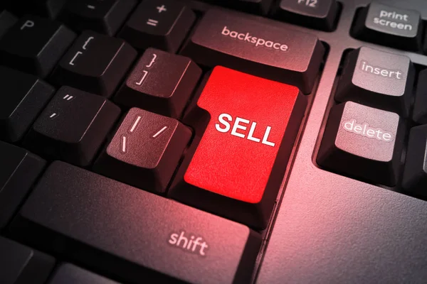 The red Sell key on the computer keyboard. Sale of assets. The concept of e-commerce. The black keyboard with the red button to Sell. A signal to sell securities.