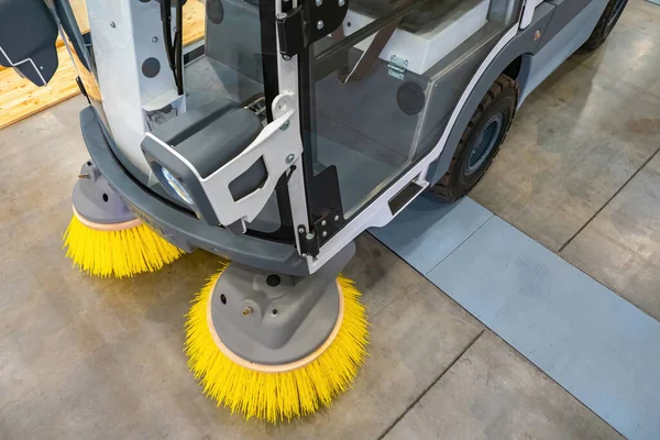 Fragment of a sweeping harvester. Concept is an electric street cleaning machine. Sweeper cab and brushes close-up. Cleaning equipment for cleaning streets. Electric sweeping equipment.