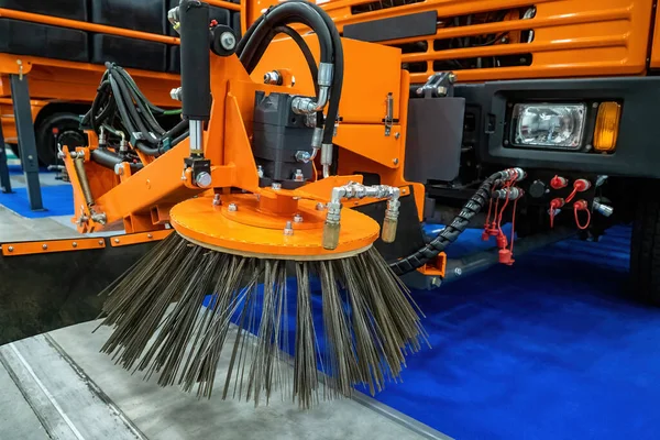Special equipment for street cleaning. Sweeping brush - cleaning machine close-up. Fragment of a street sweeping machine. Service car for street cleaning. Sweeping machine inside hangar