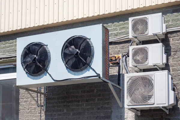 Cooling system in enterprise. External blocks of air conditioners. Blocks from air conditioners hang on facade of building. Air cooling system at enterprise. Sale of cooling equipment.