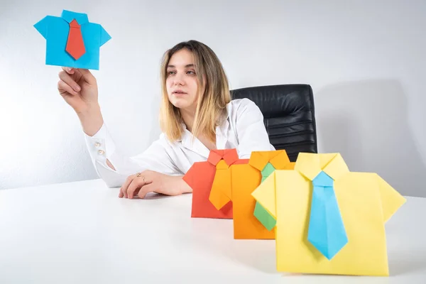 Recruiter at work. Paper person as a staff symbol. Woman recruiter selects a candidate for promotion. Girl makes a career as a recruiter. She selects employee for a vacant position