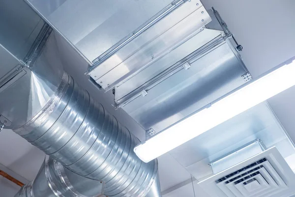 Industrial ventilation equipment. Ventilation pipes with grille. Piping systems installed on ceiling of industrial building. Organization of ventilation system. Concept - room conditioning system.