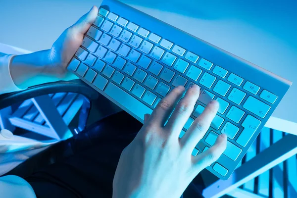 Keyboard in the hands of a person close-up. A person uses a laptop computer at home. Business, working from home, learning online. The journalist writes a new article. A blogger writes a post.