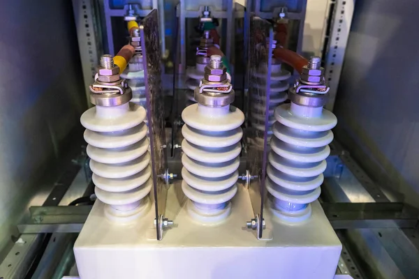 Ceramic current transformers. Spiral transformers. Equipment for generating current close-up. Fragment of equipment for electrification. White transformers are connected to something.