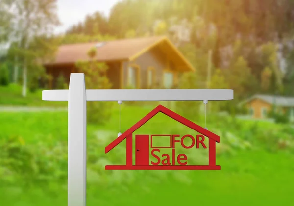 Sale of cottages. Country house for sale. For sale sign on background of modern cottage. Wooden house in background. Selling of country cottage. Buying houses in nature. Real estate trade.