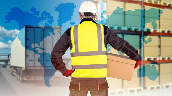 Logistic transportation concept. Man with box with his back to camera. Logistics business metaphor. Warehouse racks and truck in background. World map symbolizes international logistics.