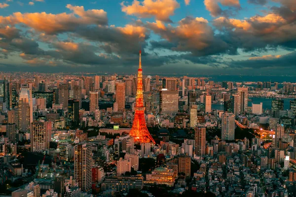 Japan, Tokyo on the background of a beautiful sky. Tokyo TV Tower towers over the city. Panorama of Tokyo with a TV tower. Top view of the Japanese city. A red TV tower under multicolored clouds.
