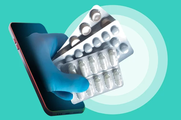 Treatment online. The doctor prescribes medications using a smartphone. The hand with the pills protrudes from the smartphone. Online pharmacy. Order medicines at home. Pills from a smartphone.