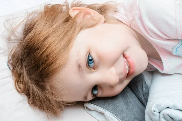 Fröhliches Kind Mit Einem Lächeln Gesicht Liegt Auf Kopfkissen Vor — Stockfoto