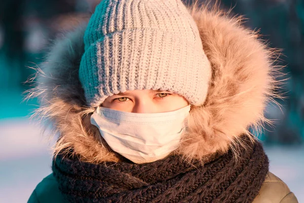 Girl in medical mask in nature