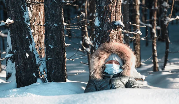 冬の森の中で目を閉じて木の下のマスクの女の子 — ストック写真