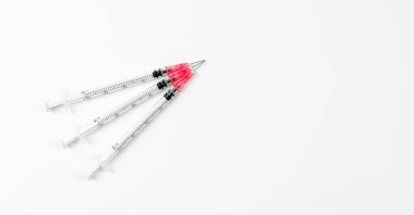 Beyaz arka planda üç şırınga. Coronavirus aşısı ve enjeksiyon konsepti. Grip aşısı