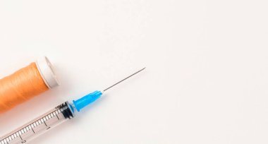 Beyaz arka planda dikiş ipliği olan şırınga. Operasyon ve yara dikiş konsepti