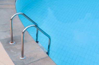 Yüzme havuzunda kaldırma ve inme için tırabzanları olan merdivenler.