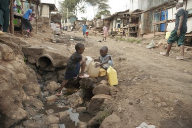 Çocukları Kibera, Nairobi, Kenya bir sokakta içmek için su al.
