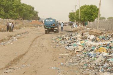 Su kamyon çöp, Juba, Güney Sudan yığınları arasında caddede gidiyor.