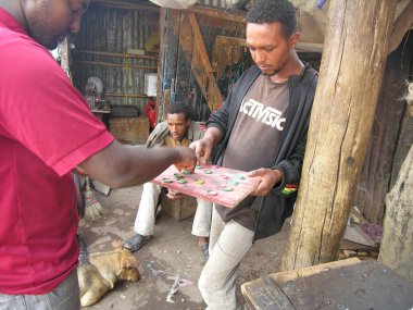 İşsiz adam Mercato Market, Addis Ababa, Etiyopya doğaçlama dama oynamak.