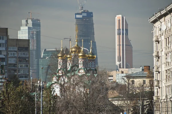 Russische kerk met wolkenkrabbers in de achtergrond, Rusland. — Stockfoto