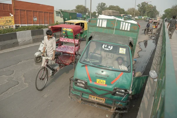 Motorista dorme na cabine de seu caminhão em uma ponte em Delhi, Índia . — Fotografia de Stock