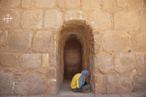 Pilgrim waits start a church service at the gate of St. Catherine's Monastery, Egypt.