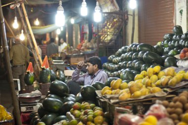 Meyve ve sebze Indore, Hindistan'da bir semt pazarı, satıcı satıyor.