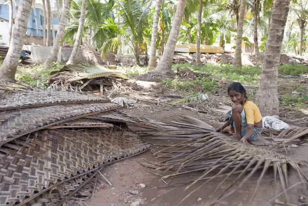 Indian woman weaves mat of dry coconut leaves in Kovalam, Kerala, India. — Stock Photo, Image