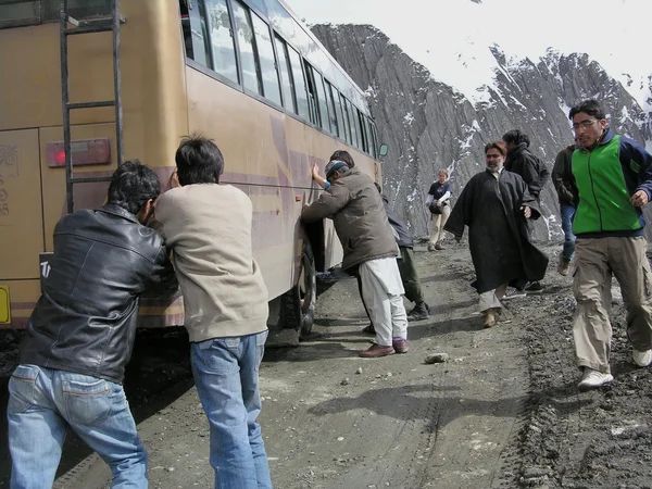 Los pasajeros empujan su autobús parado en Zoji La pass en Srinagar - Leh road, India . — Foto de Stock