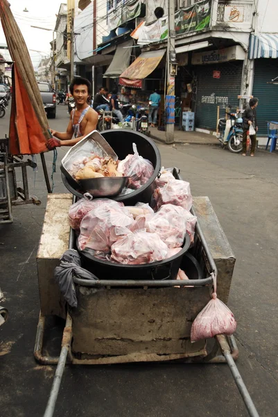 Carniceiro tailandês carrega desperdício de sua loja em Kanchanaburi, Tailândia . — Fotografia de Stock