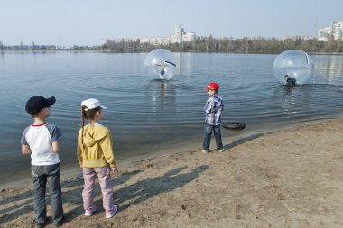 Kids wait their turn for a water zorbing in Voronezh, Russia. clipart