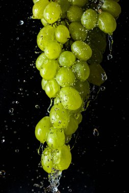 Siyah arka planda sulu nemli meyve. Elma ve üzüm.