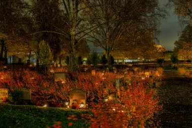 Stockholm, İsveç Cadılar Bayramı kutlamaları. Lidingo Kilisesi 'ndeki bir mezarlıkta mumlarla..