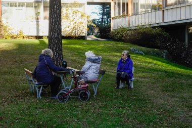 Stockholm, Sweden  Senior women sitting at a picnic table in a residential yard.