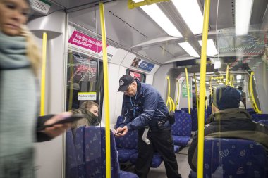 Stockholm, İsveç. Bir bilet kontrolörü, bir yolcunun metro ya da tüneldeki biletini kontrol eder..