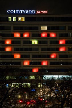 Stockholm, İsveç. Salgın sırasında büyük kırmızı bir kalp tarafından aydınlatılan Marriott Oteli 'nin avlusundaki harikalar diyarında bir kişi duruyor..