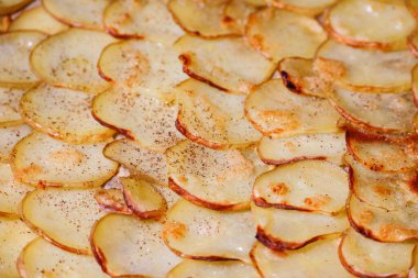 Fırın tepsisine dizilmiş dilimlenmiş patates.