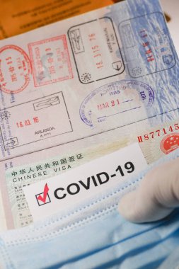 Bir Covid-19 bağışıklık belgesi, Çin vizesi ve yüz maskesi..