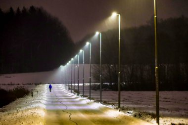 Stockholm, İsveç Huddinge 'in banliyösünde bir adam karlı ve aydınlık bir yolda yürüyor..