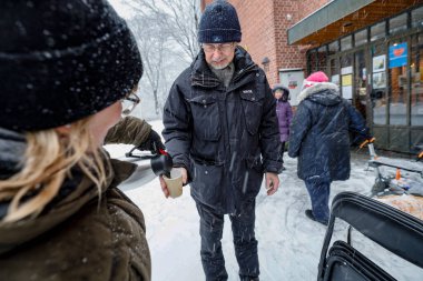 Stockholm, İsveç 'te bir grup aktif son sınıf öğrencisi ve kilise üyesi Covid-19 yüzünden Grondal' daki yerel bir kilisenin önünde kahve servisi yapıyorlar..