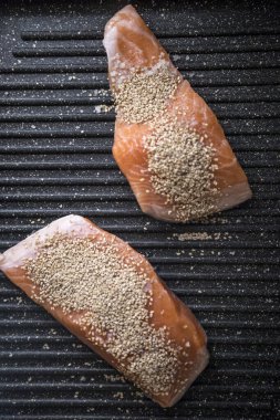 Susamlı tavada çiğ somon bifteği.