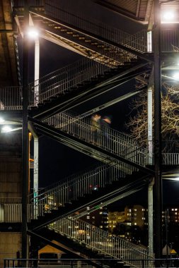 Stockholm, İsveç Bir kişi Liljeholmsbron, ya da Liljeholmen Köprüsü 'nden açık bir merdivenden iner.