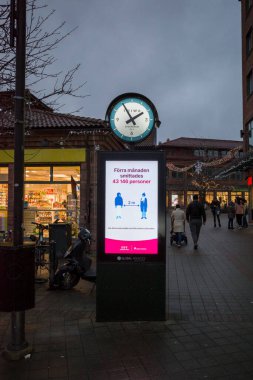 Stockholm, İsveç. Bir saat ve reklam ekranında geçen ay 43-146 kişinin Corona 'ya nasıl bulaştığını anlatan bir İsveççe yazı var..