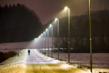 Stockholm, İsveç Huddinge 'in banliyösünde bir adam karlı ve aydınlık bir yolda yürüyor..