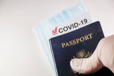 Covid-19 aşı belgesi ve yüz maskesi olan bir Amerikan pasaportu..