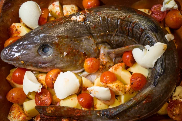 用土豆 西红柿 大蒜和木瓜做成的烤盘中的一整条波罗的海梭子鱼 — 图库照片
