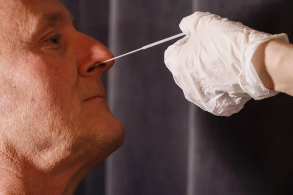 A man uses a nose swab to test for Corona.