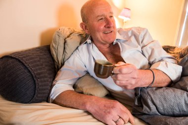 Stockholm, İsveç Bir adam yatakta kahve içiyor.