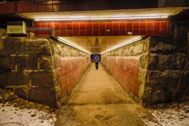 Stockholm, İsveç Tungelsta banliyösünde bir yeraltı geçidinde yürüyen bir kişi.