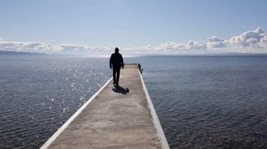 Visingso, İsveç Güneşli bir günde bir adam Vattern Gölü 'nde bir rıhtımda yürür.. 